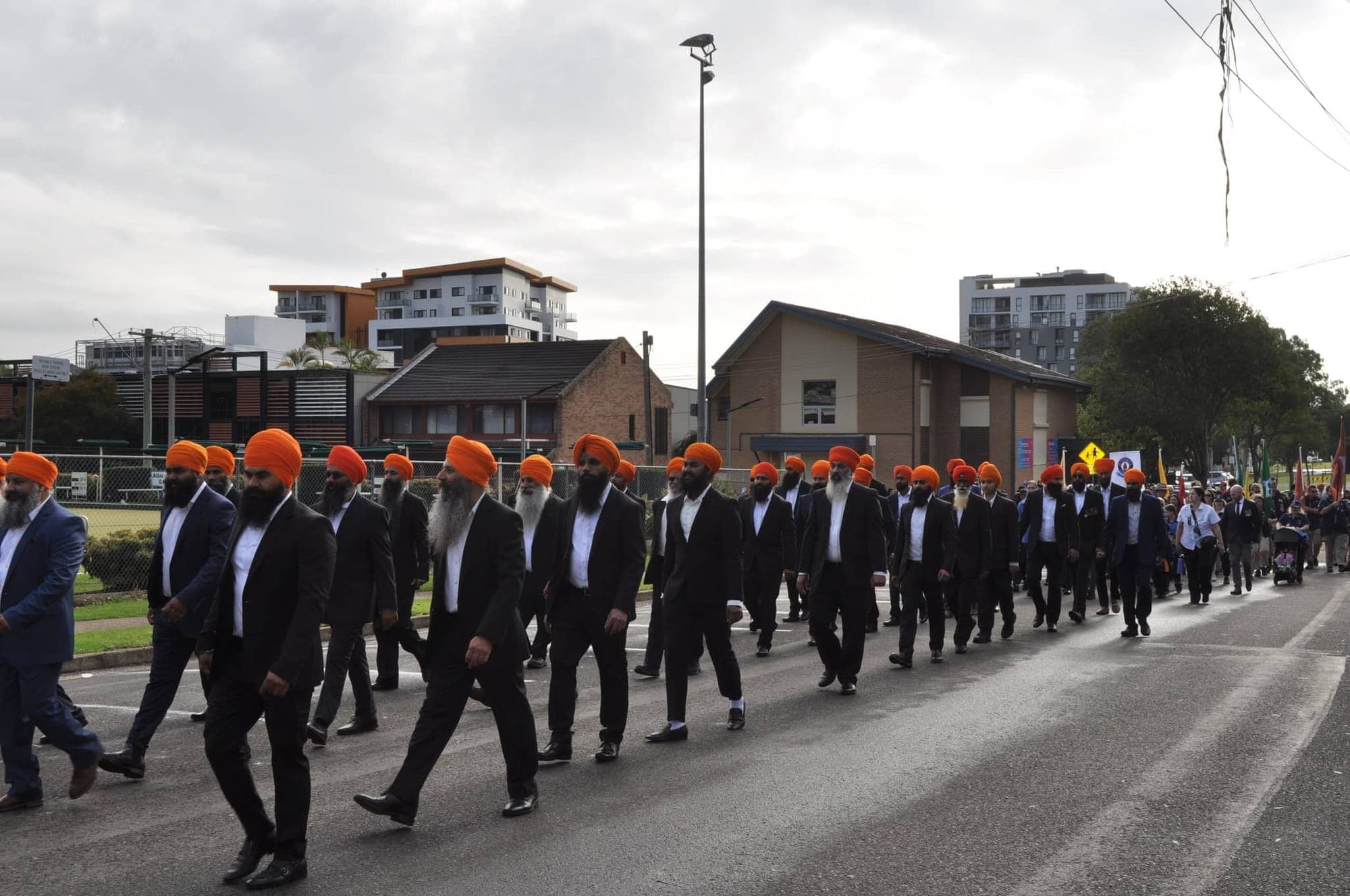AKA members marching through a park during an ANZAC Day parade