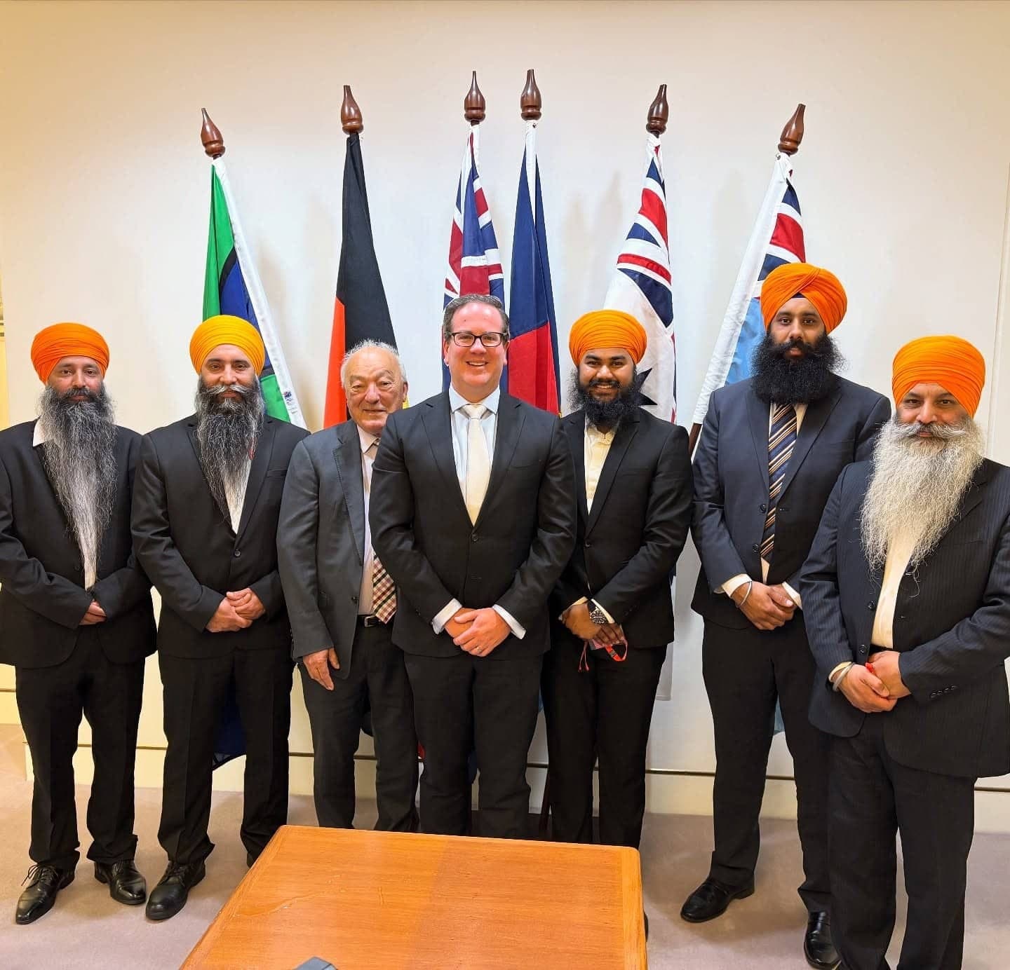 AKA representatives with government leaders in front of national flags